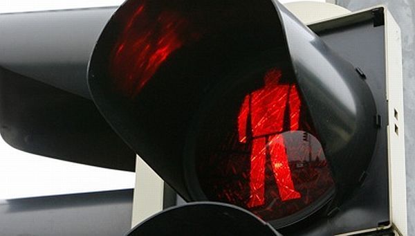 Sute de amenzi pentru pietonii surprinși în timp ce traversau strada pe culoarea roşie a semaforului
